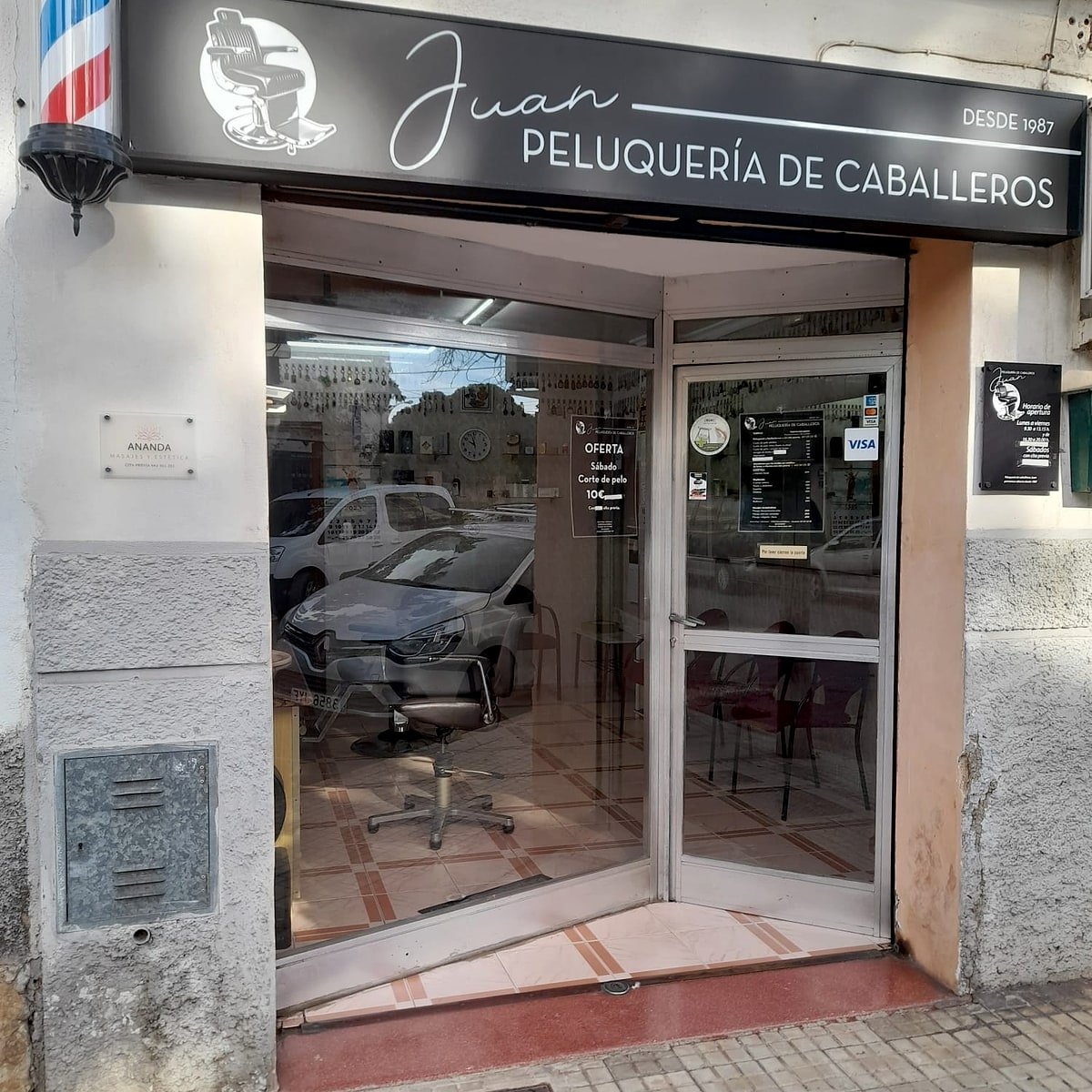 Fachada de Peluquería Juan en el Vivero, Palma — rótulo "Peluquería de caballeros desde 1989" con barber pole.