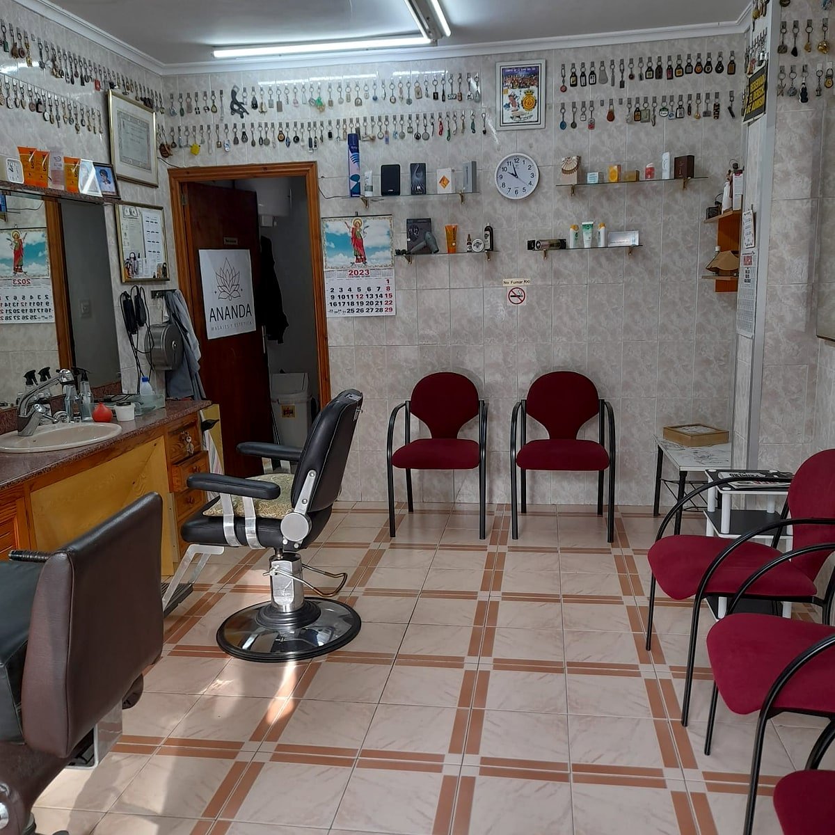 Interior del salón con la pared de llaveros característica y el sillón de barbero clásico.