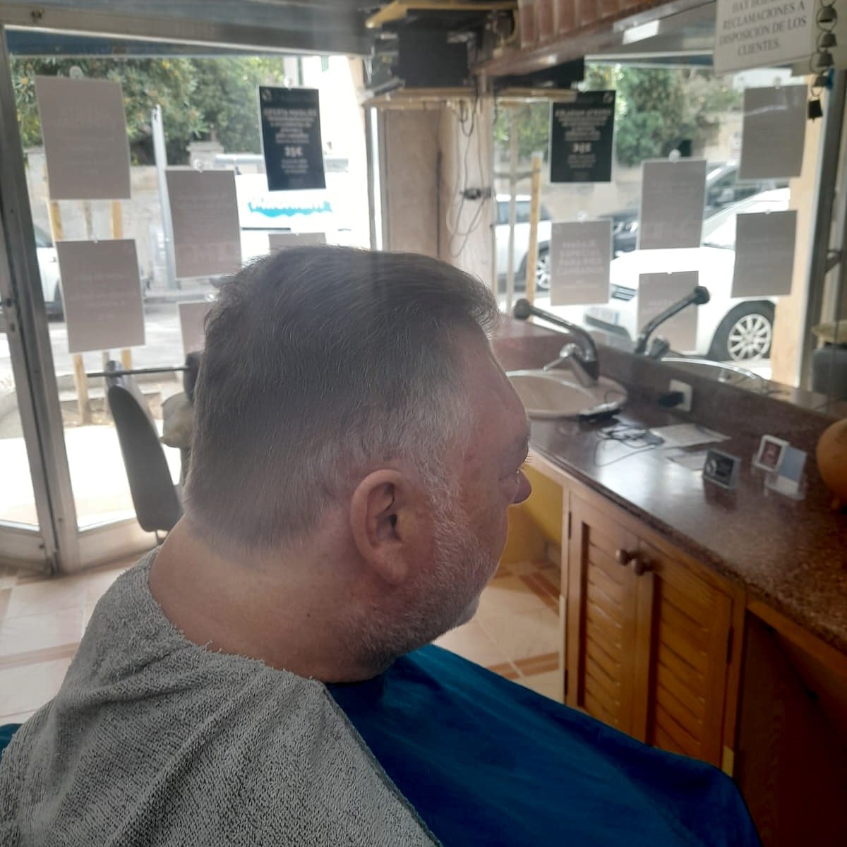 Cliente con corte clásico recién terminado, vista lateral sin rostro identificable.