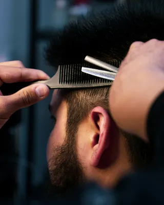 Corte clásico de caballero — peine de barbero sobre cabello, close-up editorial
