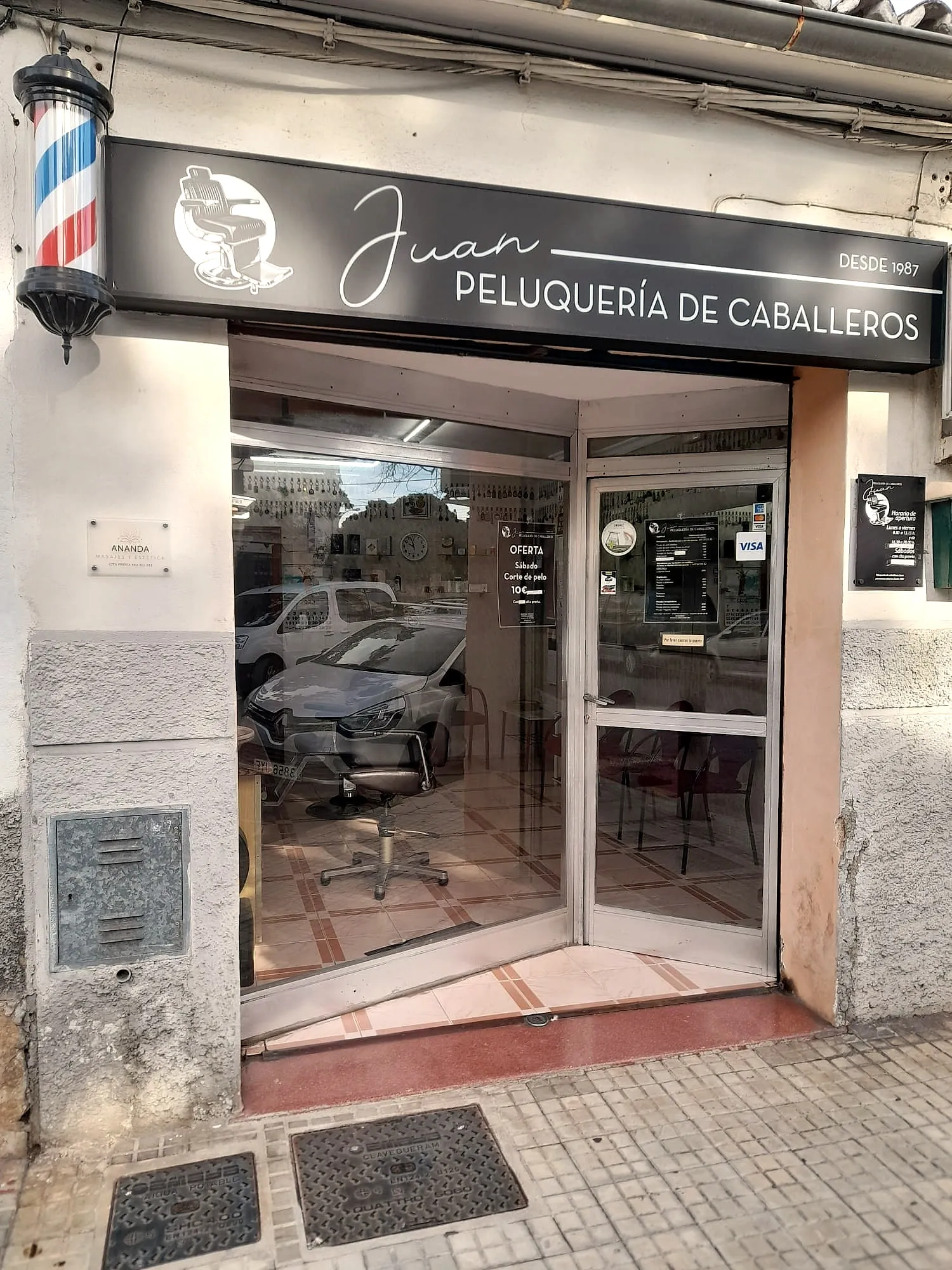 Fachada de Peluquería Juan en Carrer del Mestre Chapí 9 — rótulo y barber pole junto a la entrada
